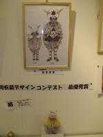 one of the winning designs, with a statuette dressed in the costume